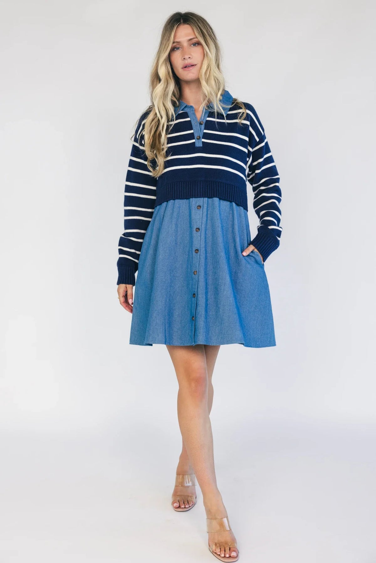 Model wearing a navy and ivory striped sweater dress with a collared neckline, functional button-front detail, long sleeves, and an elastic waist.